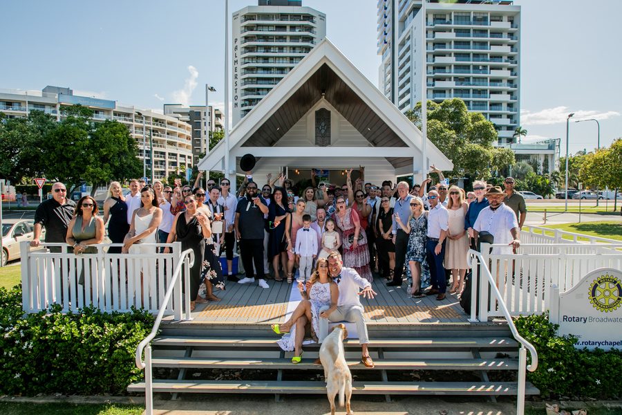 An epic group shot of a wedding party in front of a chapel