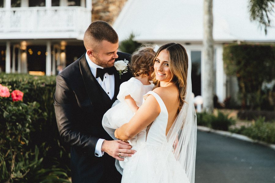 A bride and groom holding their child after a wedding ceremony - Anima Visual, Wedding photography in the Gold Coast