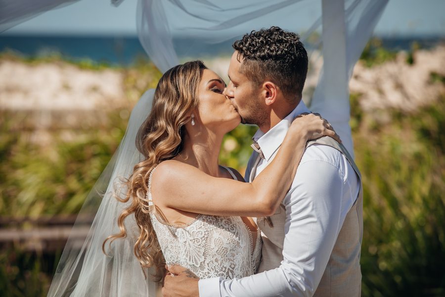 A bride and grooms first kiss at their wedding on Kingscliff beach