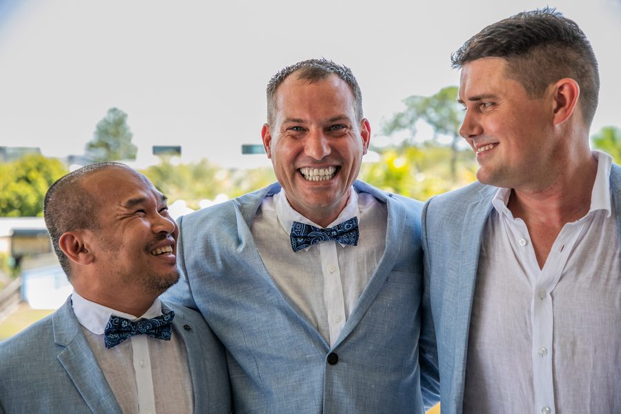 A smiling groom with his two best friends